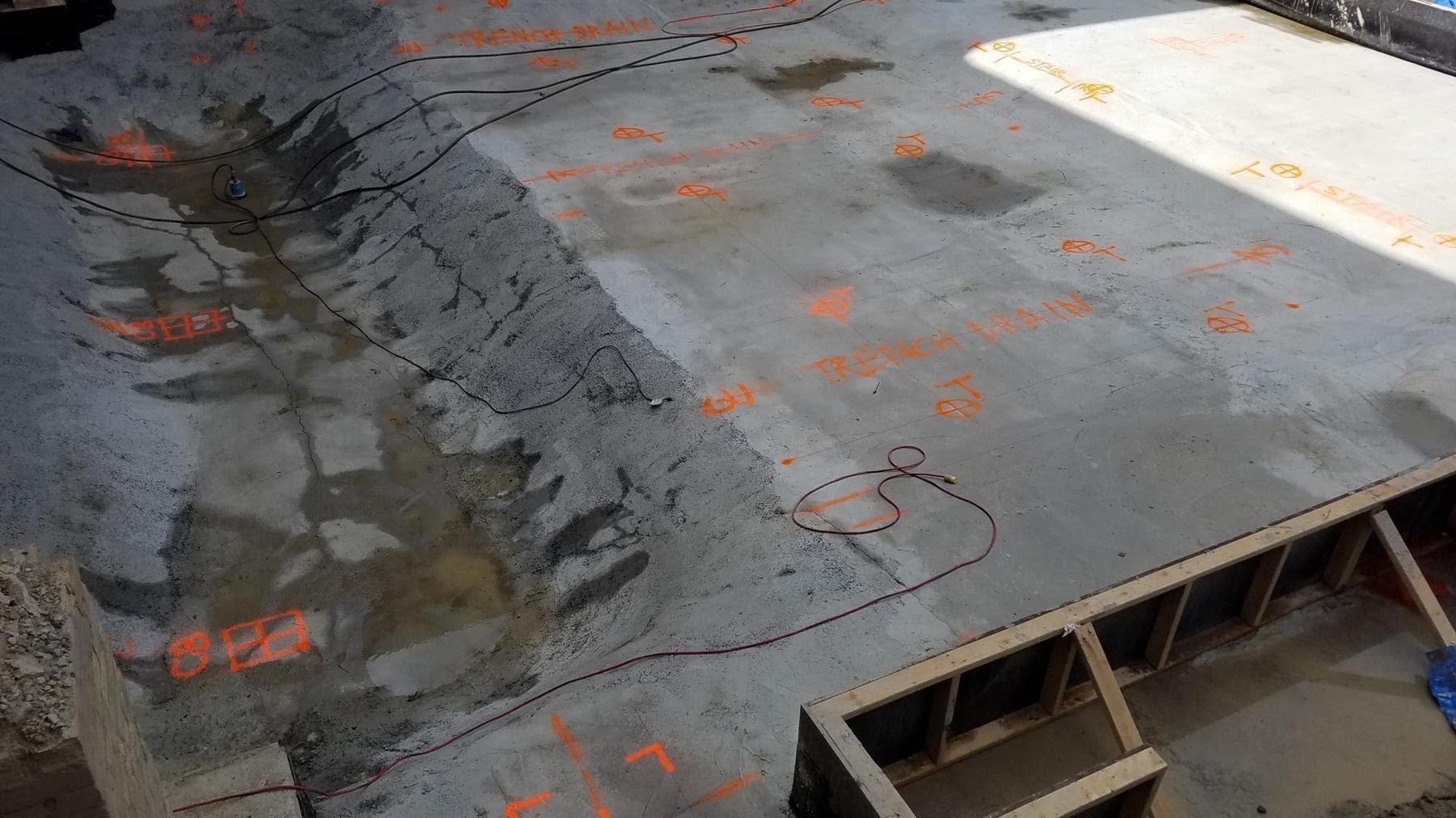 Concrete deck surface marked with layout points, control lines, and field notes
